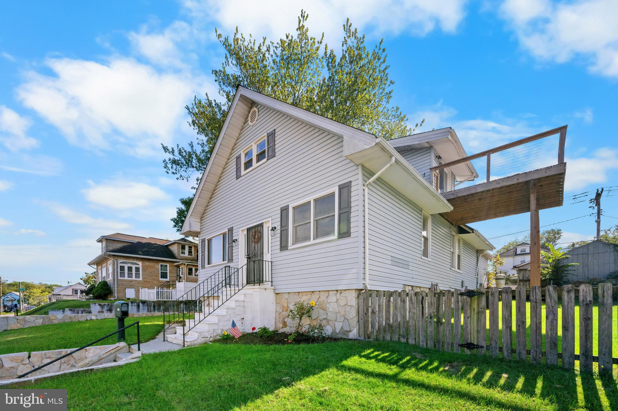113 West Edgevale Road Baltimore, MD 21225 - Photo 3 of 41 a view of a yard in front of a house with plants and wooden fence