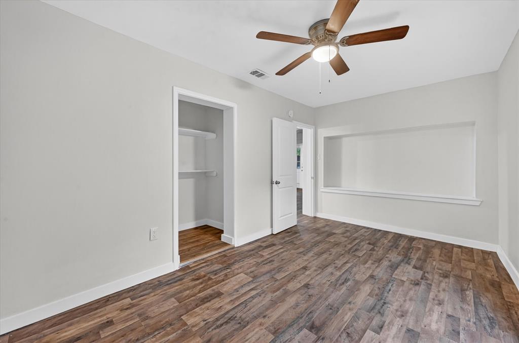 538 Pemberton Hill Road Dallas, TX 75217 - Photo 17 of 31 Spacious room featuring wood-finish flooring, light gray walls, and white trim