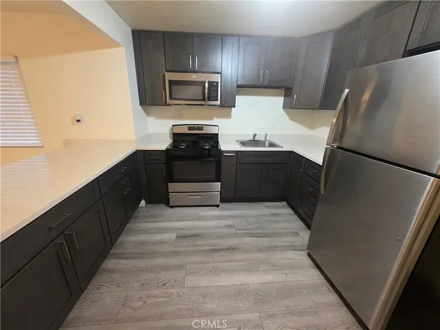 a kitchen with granite countertop a refrigerator and a stove top oven