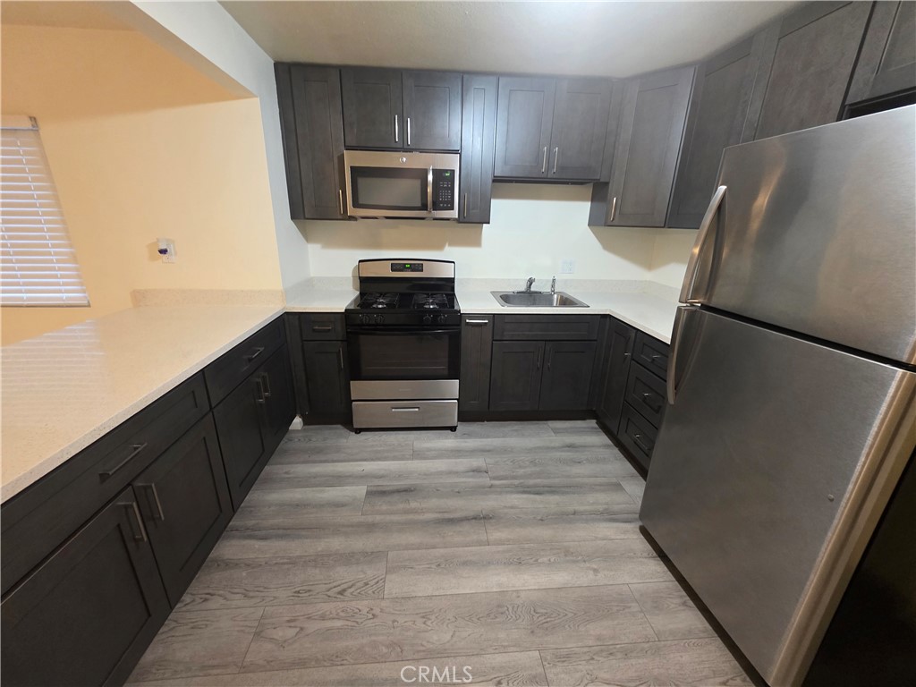 533 East 9th Stockton, CA 95206 - Photo 4 of 6 a kitchen with granite countertop a refrigerator and a stove top oven