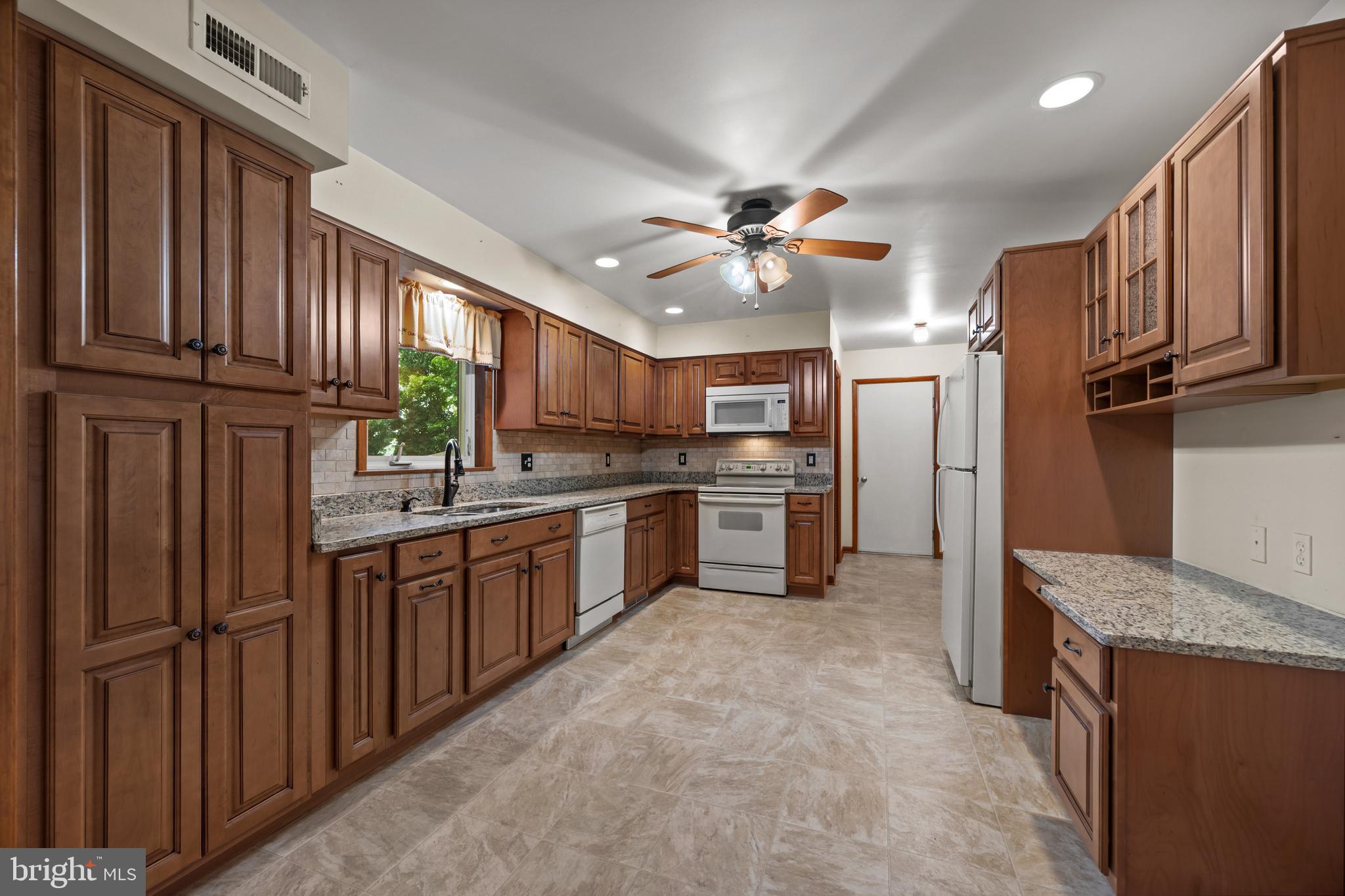 5313 Wentz Road Manchester, MD 21102 - Photo 4 of 51 a kitchen with stainless steel appliances granite countertop a refrigerator a sink dishwasher and wooden cabinets with wooden floor