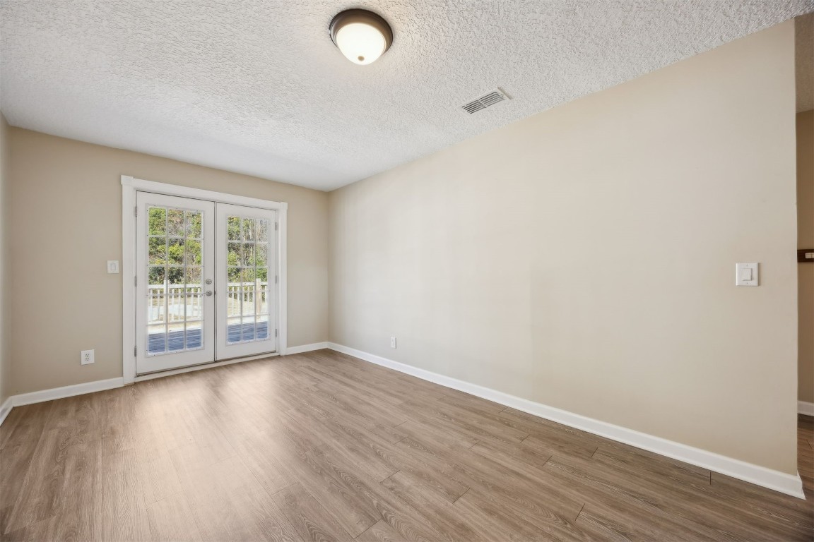 87529 Roses Bluff Road Yulee, FL 32097 - Photo 11 of 38 an empty room with wooden floor and windows