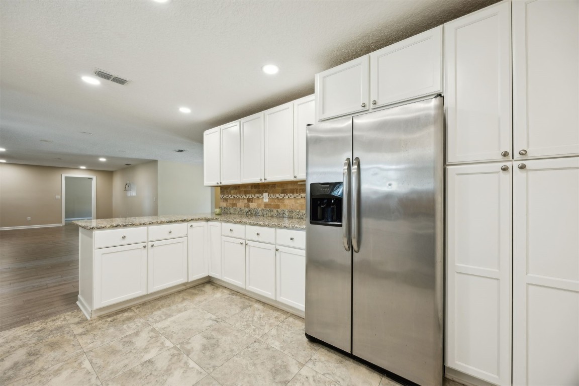 87529 Roses Bluff Road Yulee, FL 32097 - Photo 14 of 38 a kitchen with a refrigerator and white cabinets