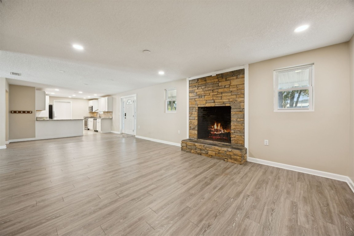 87529 Roses Bluff Road Yulee, FL 32097 - Photo 9 of 38 an empty room with wooden floor fireplace and windows