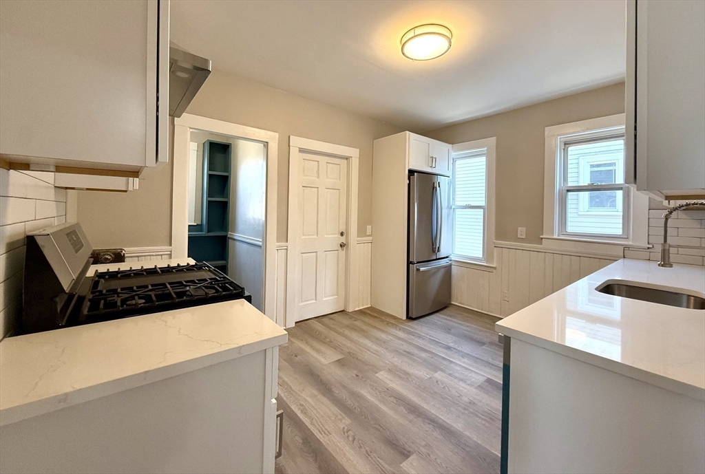 69 Conwell Avenue, Unit 2 Somerville, MA 02144 - Photo 11 of 14 a kitchen with stainless steel appliances granite countertop a sink stove and refrigerator