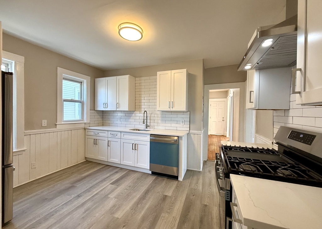 69 Conwell Avenue, Unit 2 Somerville, MA 02144 - Photo 13 of 14 a kitchen with a white stove top oven sink and cabinets