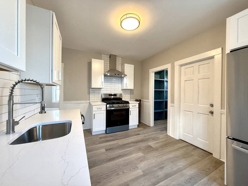 69 Conwell Avenue, Unit 2 Somerville, MA 02144 - Photo 14 of 14 a kitchen with a sink stove top oven and refrigerator