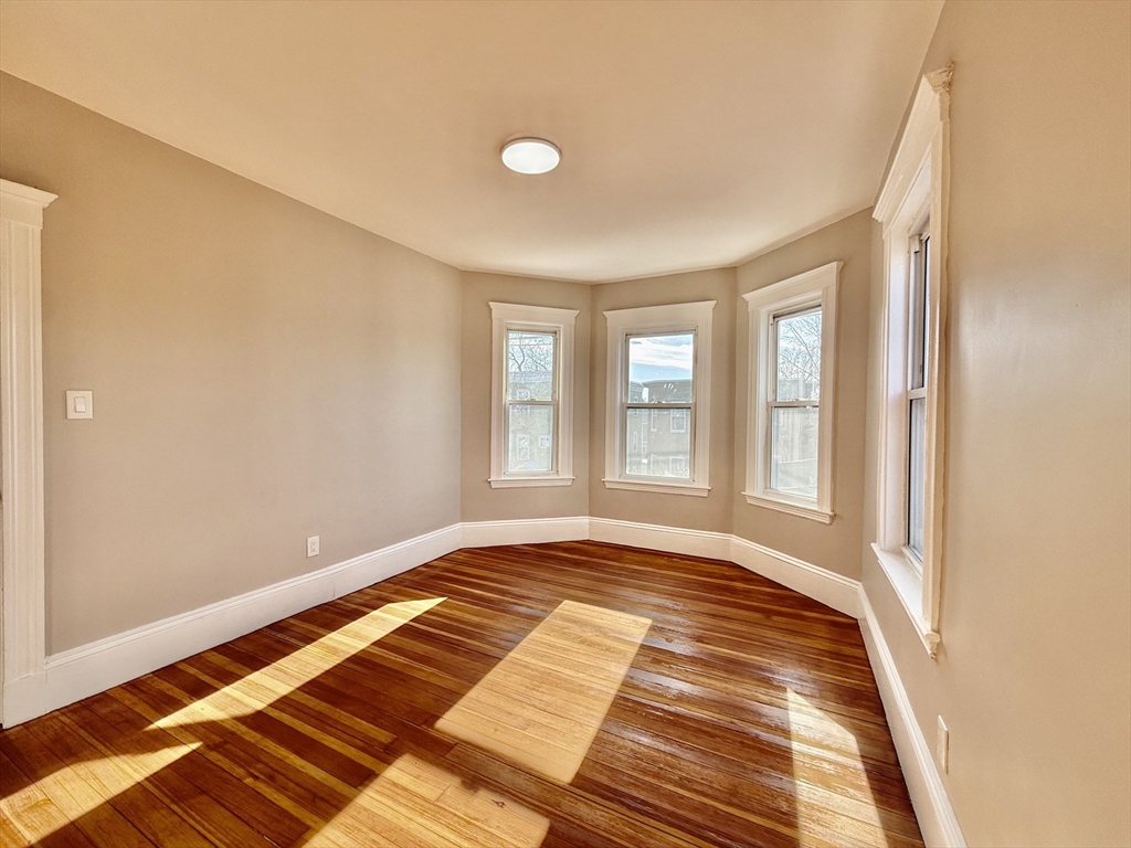 69 Conwell Avenue, Unit 2 Somerville, MA 02144 - Photo 5 of 14 a view of a room with wooden floor and windows