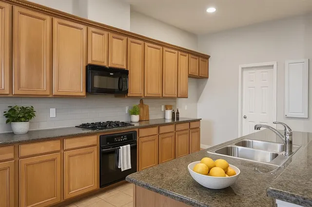 a kitchen with a stove a sink and cabinets