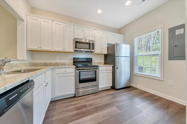 a kitchen with stainless steel appliances granite countertop a stove a sink and a microwave