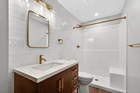 a bathroom with a sink toilet a mirror and shower