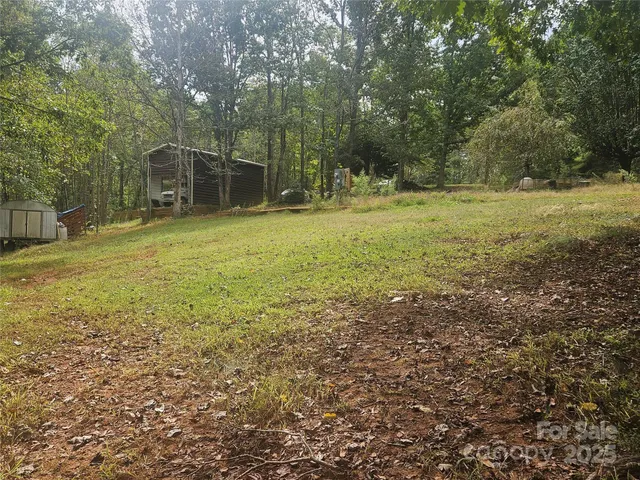 a backyard of a house with lots of green space and a chair