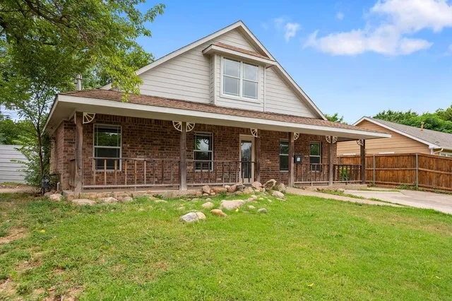 a front view of a house with a yard and garden