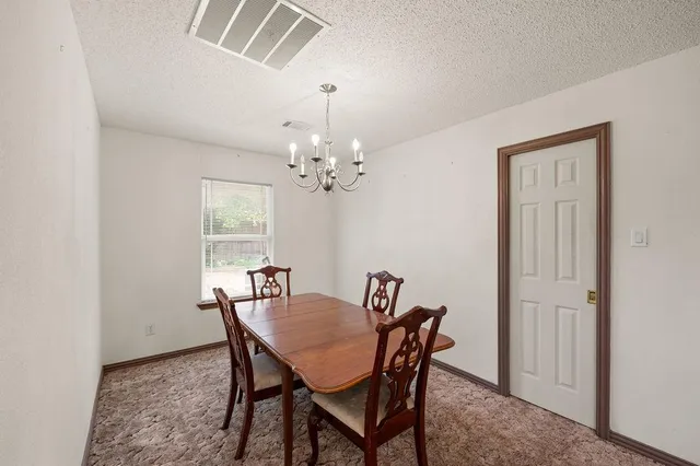 a view of a dining room with furniture and chandelier