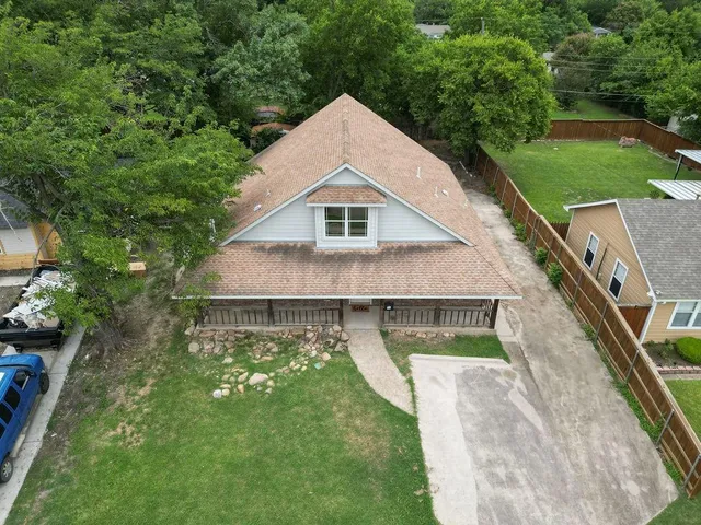 a aerial view of a house with swimming pool next to a big yard