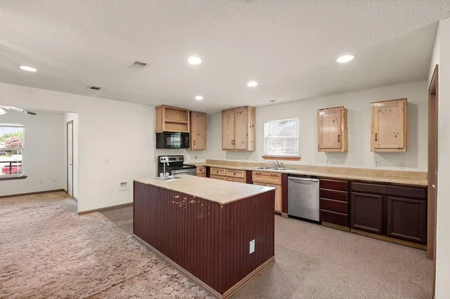 a large kitchen with stainless steel appliances granite countertop a large counter top and a stove