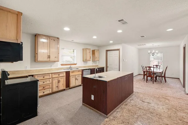 a large kitchen with kitchen island a sink table and chairs