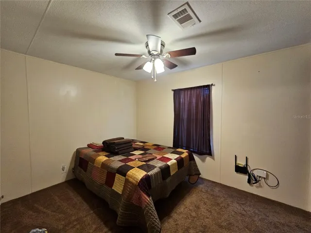 a bedroom with a bed and a ceiling fan