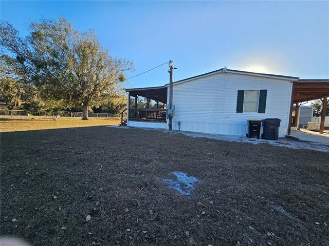 a view of a house with backyard and trees