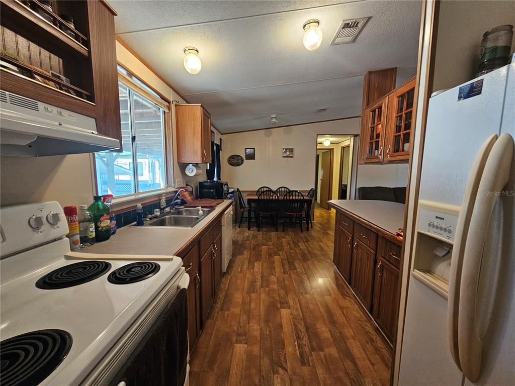 14381 Camp Mack Road Lake Wales, FL 33898 - Photo 7 of 52 a kitchen with refrigerator a stove and wooden floor