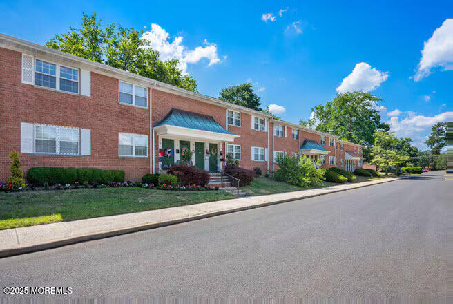 240 South Lincoln Avenue, Unit 16 Elberon, NJ 07740 - Photo 1 of 7 a front view of a house with a yard and a garage
