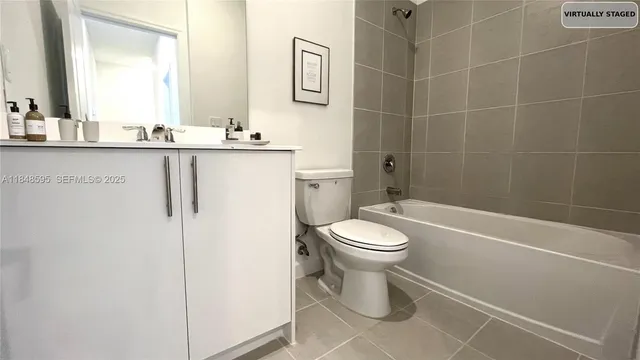 a bathroom with a toilet sink vanity tub and shower
