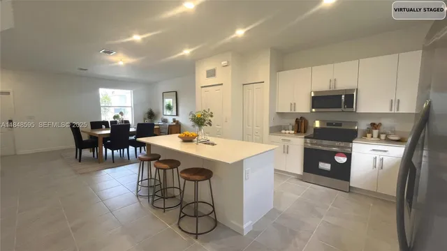 a kitchen with granite countertop a sink a counter top space stainless steel appliances and cabinets