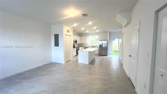 a view of a kitchen with a refrigerator and a sink