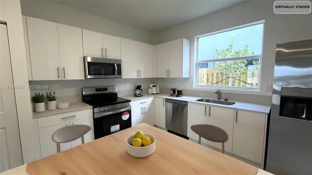 a kitchen with a sink a stove a microwave and wooden cabinets