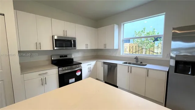 a kitchen with a stove a sink and a microwave