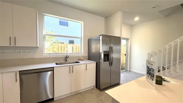 a kitchen with stainless steel appliances a sink stove and refrigerator