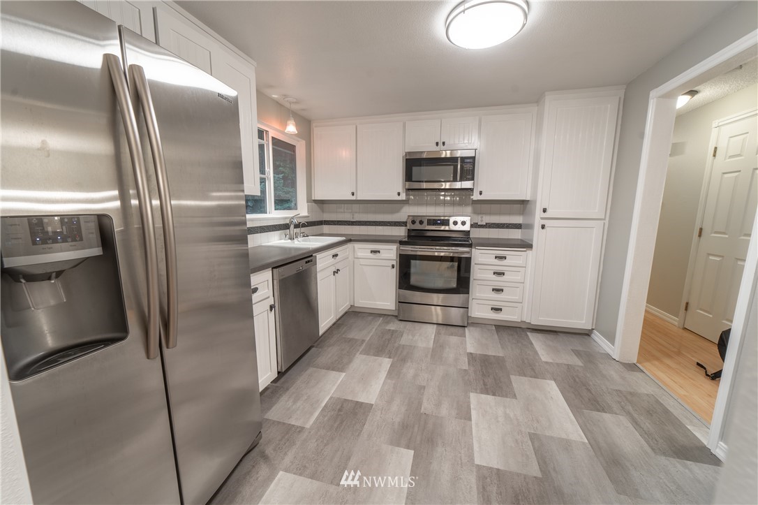 2619 164th Place Southeast Bothell, WA 98012 - Photo 2 of 19 a kitchen with stainless steel appliances granite countertop a refrigerator a stove and a sink