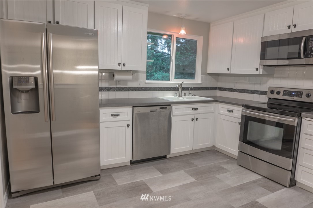 2619 164th Place Southeast Bothell, WA 98012 - Photo 3 of 19 a kitchen with a stove sink and refrigerator