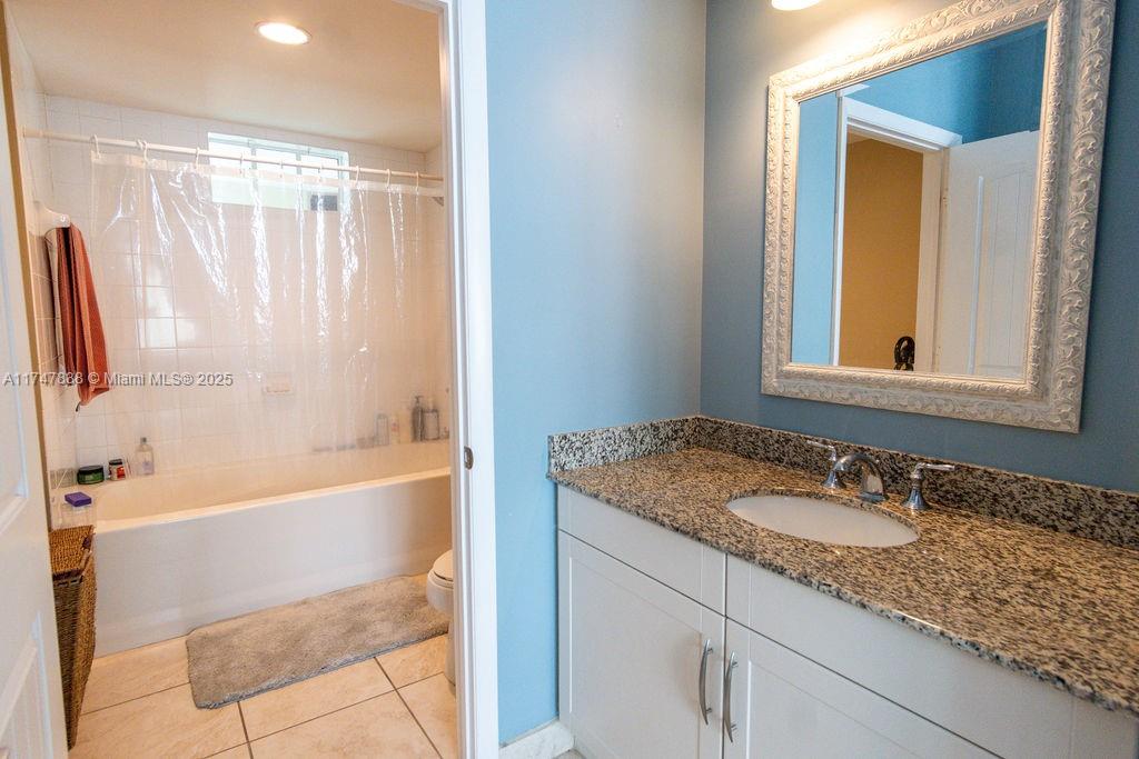 7270 Southwest 88th Street, Unit B308 Miami, FL 33156 - Photo 13 of 38 a bathroom with a granite countertop sink and a mirror