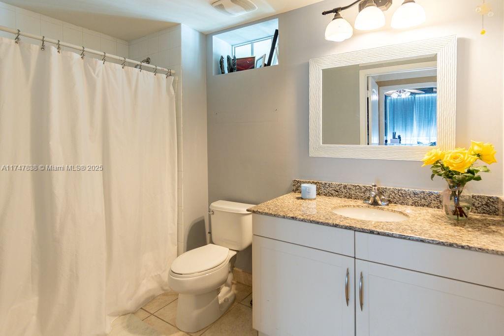 7270 Southwest 88th Street, Unit B308 Miami, FL 33156 - Photo 23 of 38 a bathroom with a granite countertop sink and a mirror