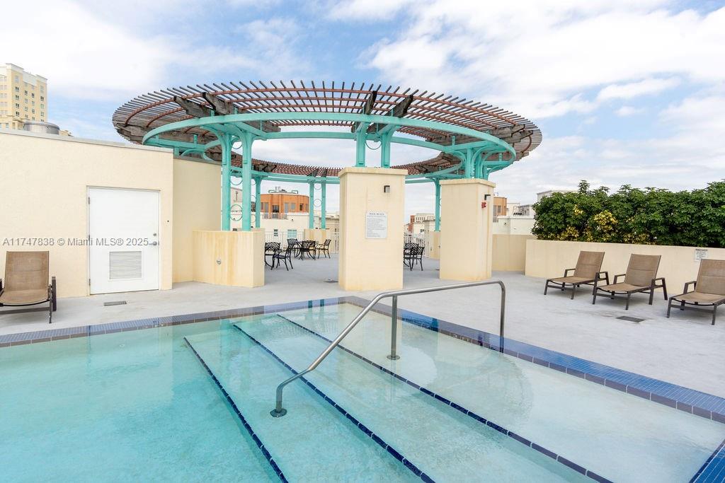 7270 Southwest 88th Street, Unit B308 Miami, FL 33156 - Photo 35 of 38 a patio with a table and chairs under an umbrella