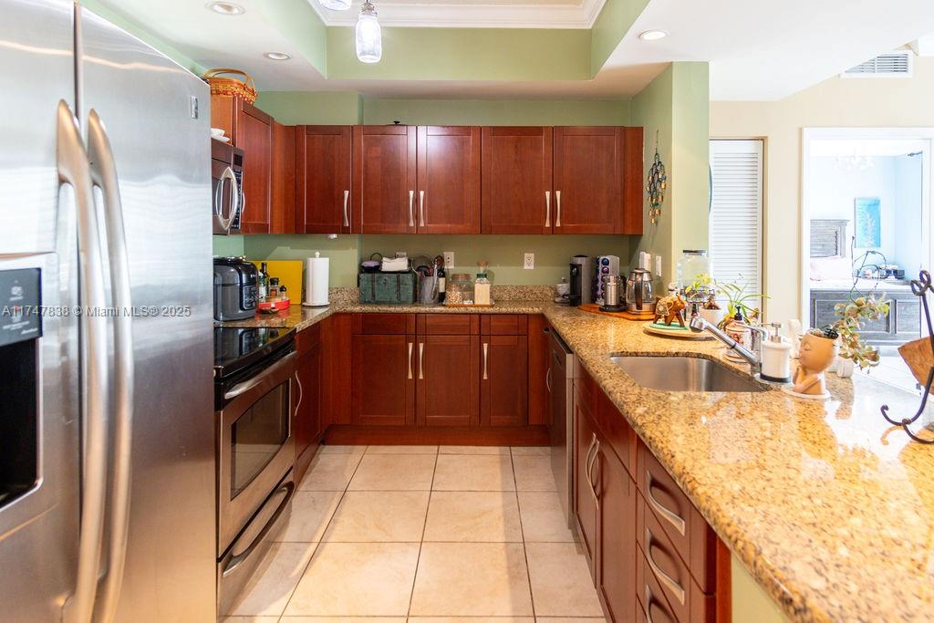 7270 Southwest 88th Street, Unit B308 Miami, FL 33156 - Photo 4 of 38 a kitchen with stainless steel appliances granite countertop a sink a stove and a refrigerator