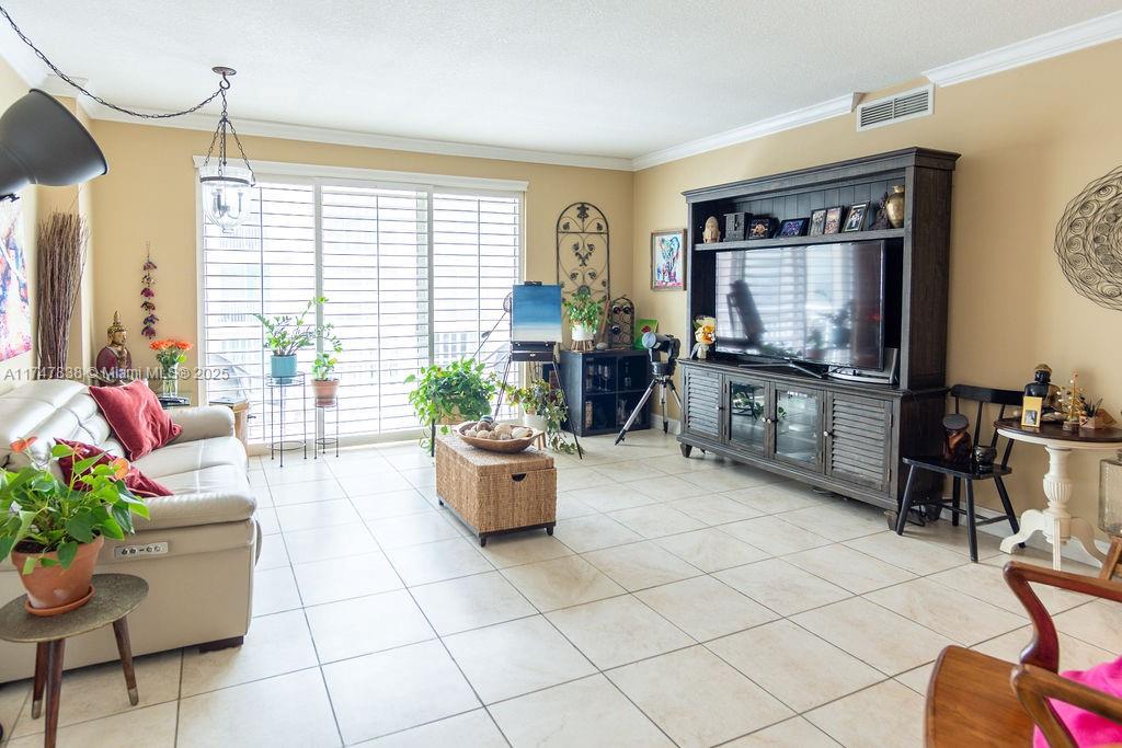 7270 Southwest 88th Street, Unit B308 Miami, FL 33156 - Photo 7 of 38 a living room with furniture and a flat screen tv