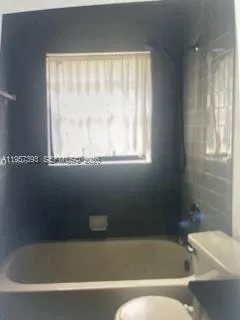 a bathroom with a bathtub and window