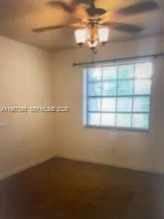 a view of a room with windows and ceiling fan