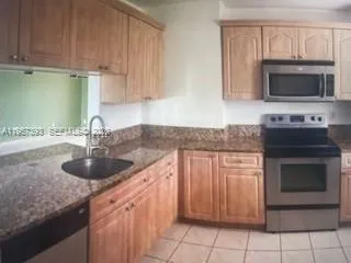 a kitchen with granite countertop a sink and a stove