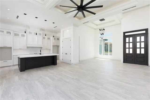 a view of a kitchen with kitchen island a sink wooden floor and a large window