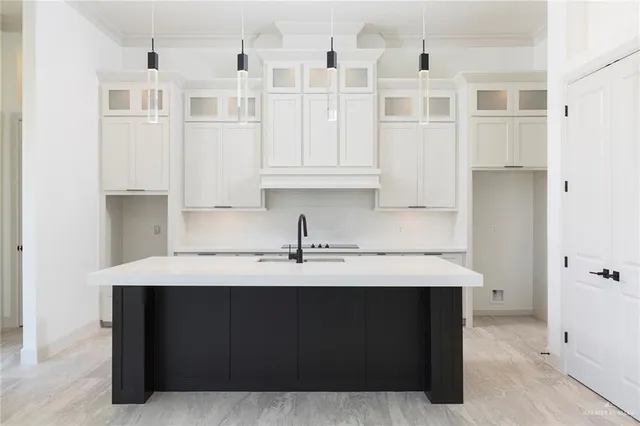 a kitchen with granite countertop white cabinets and sink
