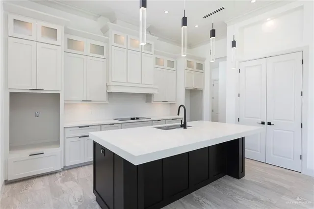 a kitchen with a sink dishwasher and white cabinets