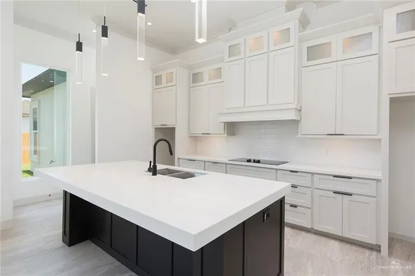 a kitchen with stainless steel appliances granite countertop a sink dishwasher and white cabinets with wooden floor