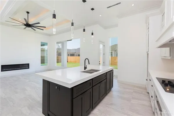 a kitchen with a sink dishwasher and a stove with wooden floor