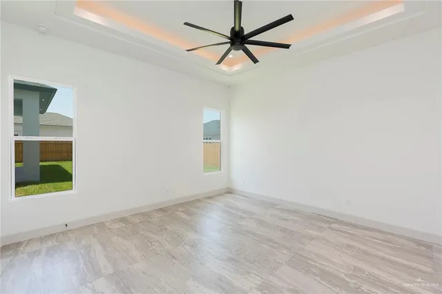 an empty room with a window and a fan