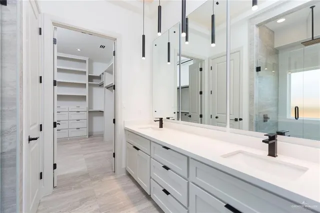 a spacious bathroom with a double vanity sink mirror and shower