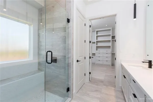 a bathroom with a shower sink and mirror