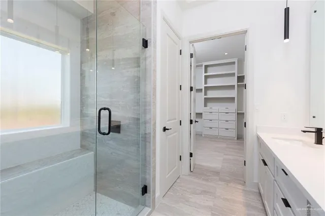 a bathroom with a shower sink and mirror